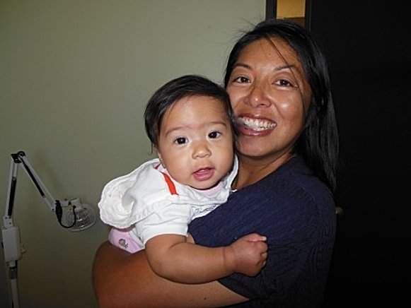 Patient smiling holding her baby girl